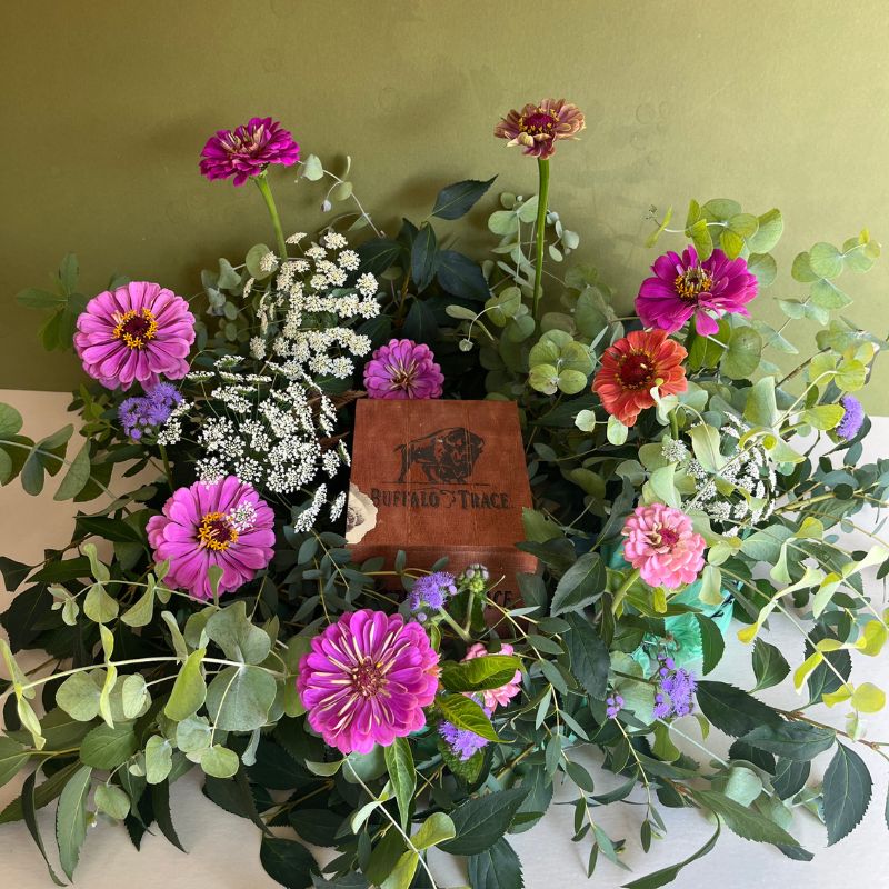 Cremation box surrounded by purple and white flowers